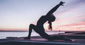 Une femme faisant du yoga au bord de la plage