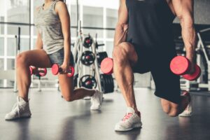 sport piscine ou sport en salle : couple qui fait des fentes avec des poids