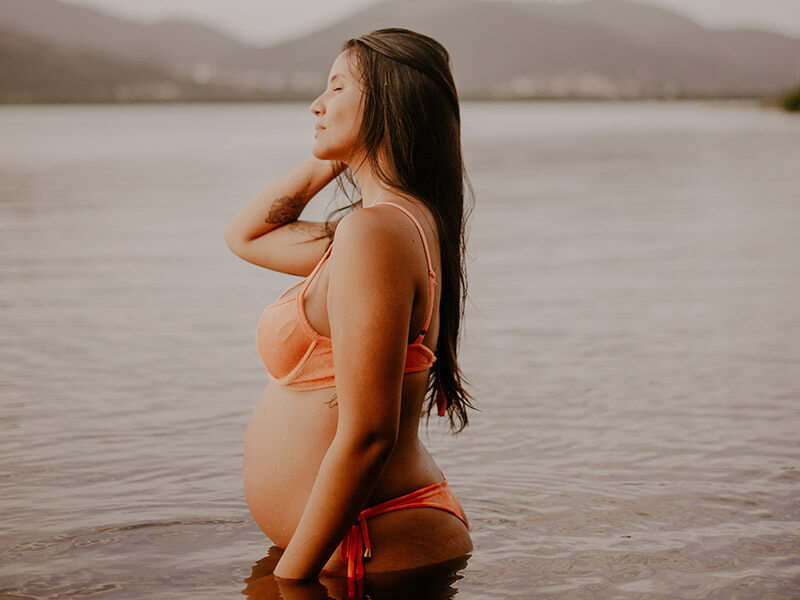 A pregnant woman with her legs in the sea