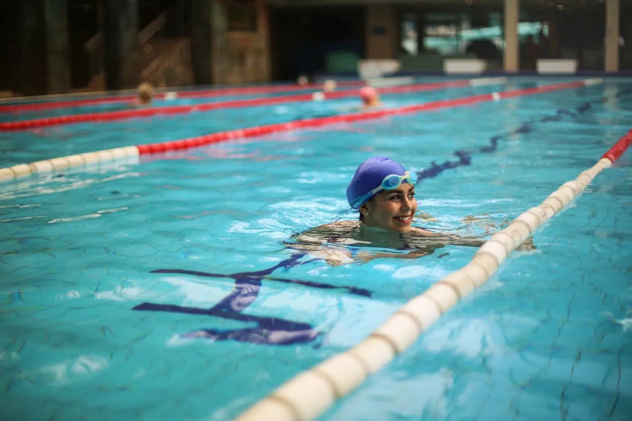 Une femme nage et fait des exercices de rééducation en piscine