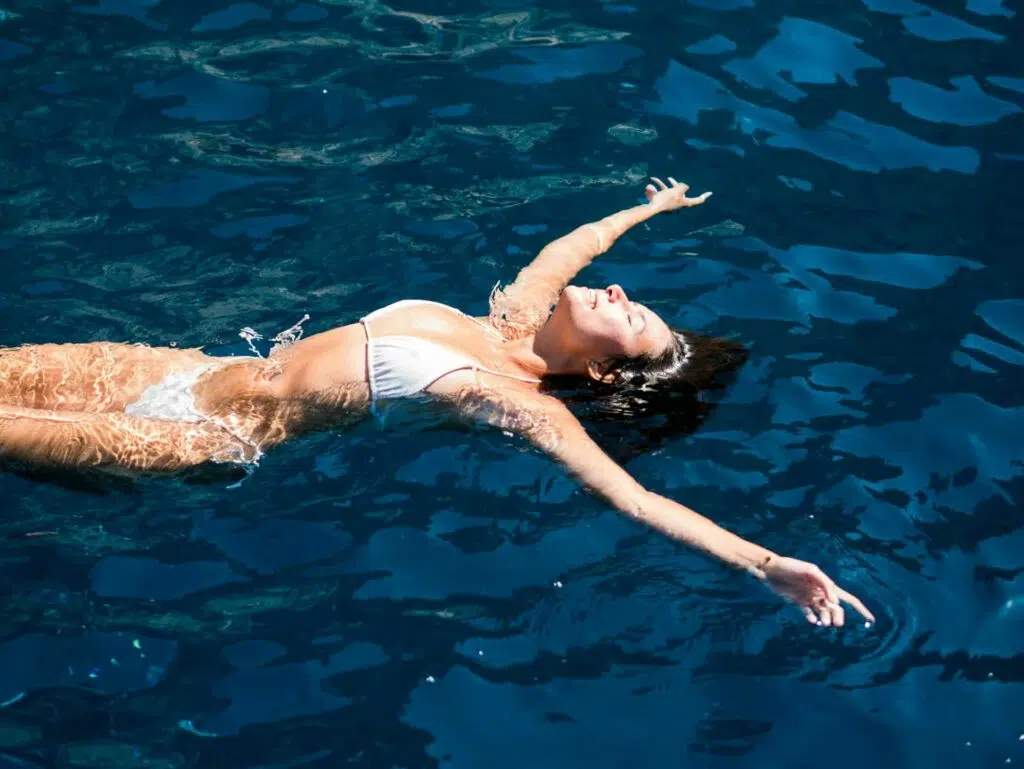 Exercice aquagym abdo : une femme fait la planche dans l'eau