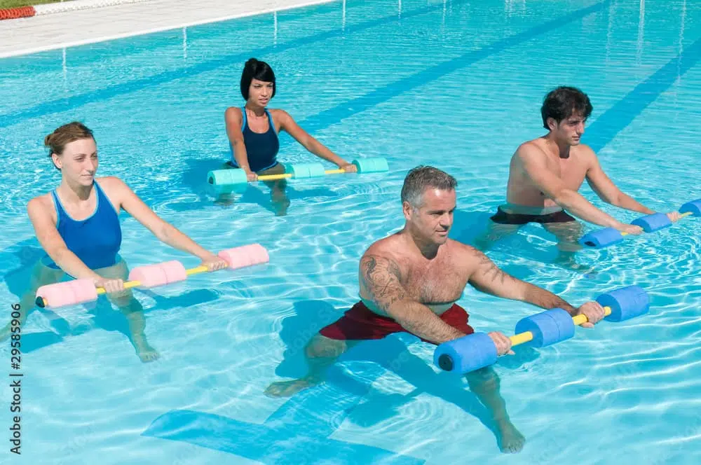 Un groupe de personnes s'entraîne à l'aquawork avec des frites