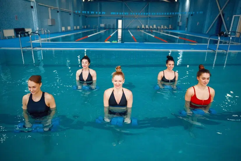 Exercice aquagym abdo fessier : un groupe de femme fait un exercice d'aquagym