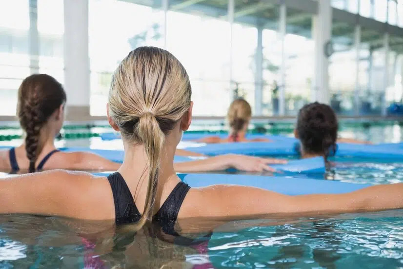 Exercice aquagym abdo fessier : des femmes font un exercice d'aquagym avec une frite